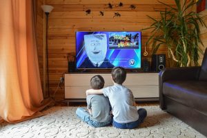 kids watching movie on a flat screen tv