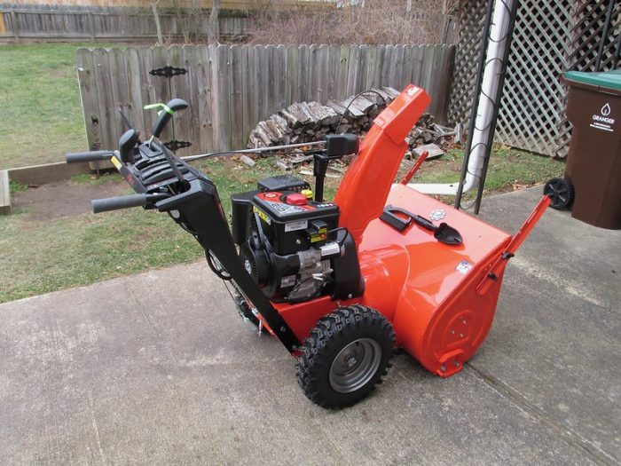 A red snow blower machine 