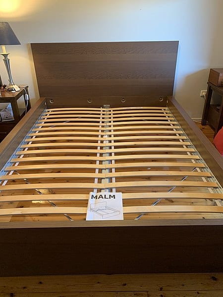 This is a wooden platform bed frame. Start with choosing the material you want. You’ll also need to choose between solid ones and those that have slats.  We’ll further show you some of the options available on Amazon in this article. Wood podium cots can have all sorts of looks from rustic to contemporary