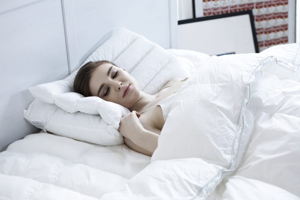 woman sleeping with down comforter