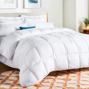 Perfect Down Comforters: A bright and inviting bedroom featuring a luxurious white down duvet with elegant stitching, complementing the crisp bedding and vibrant accents for a serene resting space.