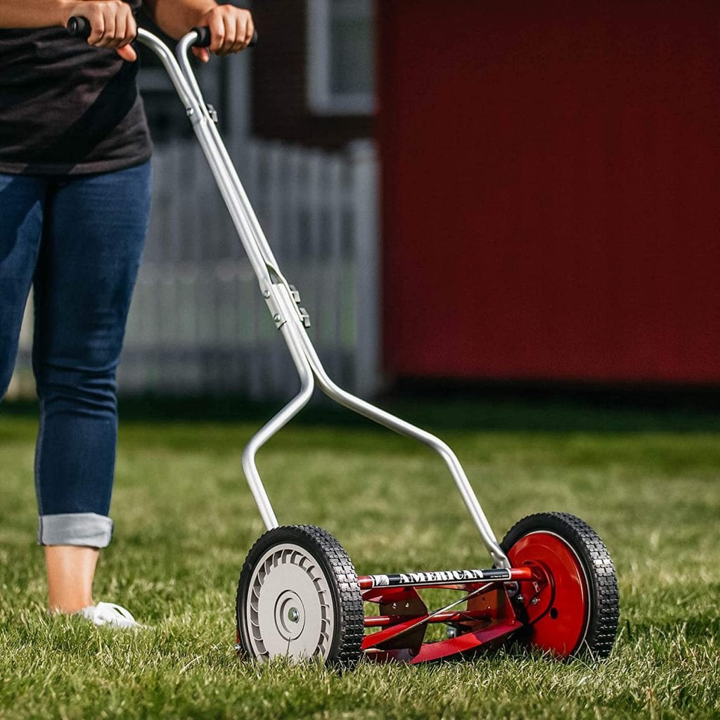 Reel mower being used by a lady. New reel mower. Sturdy reel mower.