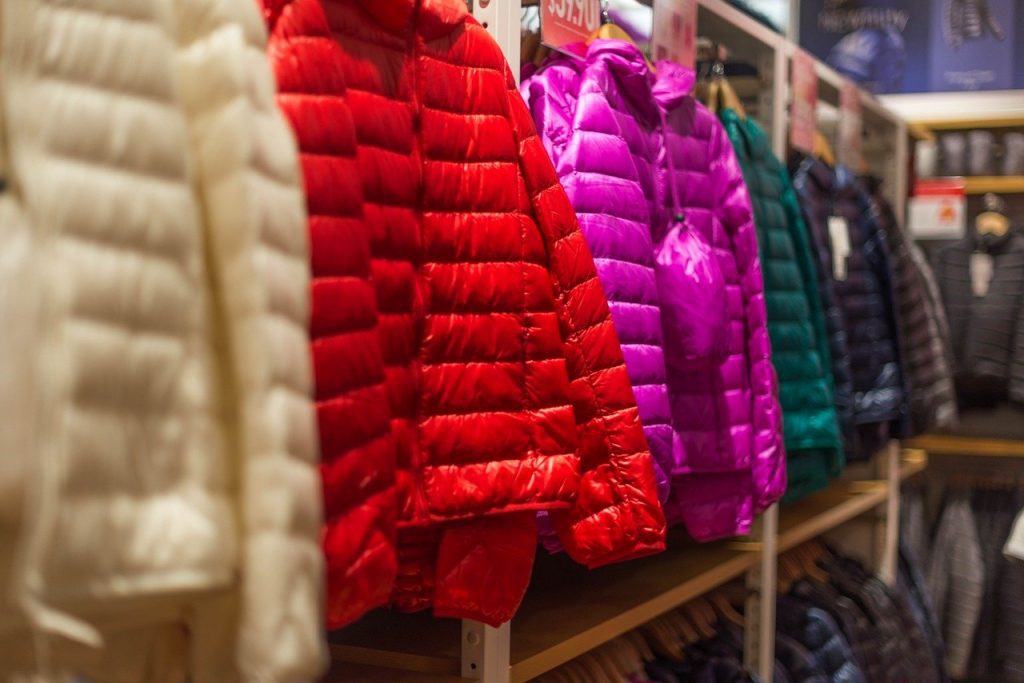 Down Jackets in different colors. Jackets in various hues and patterns. An array of colors hanging in the store, promising cozy adventures ahead.