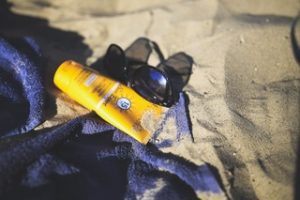 sunscreen and shades in the beach towel