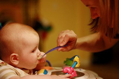 A parent feeding her baby a formula. Pick the best baby cereal.