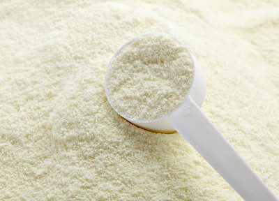 A white scoop placed on top of a powdered Loulouka formula for infants.