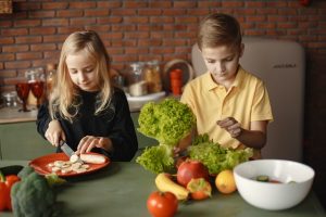 Kids eating fruits and vegetables rich in iron. Fruits and vegetables are packed with vitamins and minerals, all essential for their development.