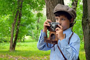 A boy holding a kids camera that's great for summer vacation. 