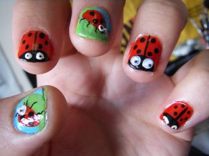 A person shows her bright lady bug summery vacation nail designs after doing the nail designs activity inside the room. 