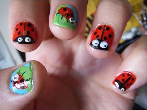A person shows her bright lady bug summery vacation nail designs after doing the nail designs activity inside the room.