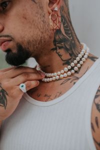 A man wearing beaded accessories for style elevation and to match his attire during the hot season break.