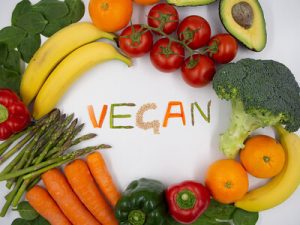 A display showing various kinds of fruits and vegetables with the word vegan at the center. Mary ruths vitamins