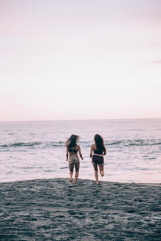 Holiday vacations at the beach. Arriving at their beachfront paradise, teens are greeted by a mesmerizing panorama of crystal-clear waters as far as the eye can see, bordered by soft, powdery sand that invites barefoot adventures. These teens are enjoying the holiday - just the two of them with each other's support.