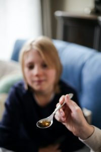 A mother giving liquid vitamins to her child. Supplements in this form gets absorbed by the body faster and better.