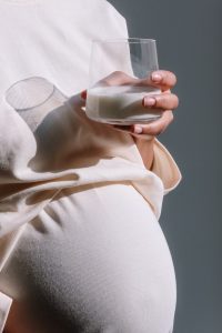 An expecting mother about to drink her prenatal vitamins. Prenatal supplements are the best way to ensure that you and your baby are getting enought nutrients.