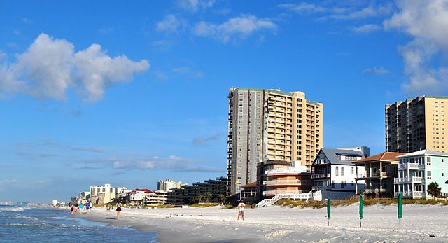 There is a beach with buildings that is good for summer trips. 