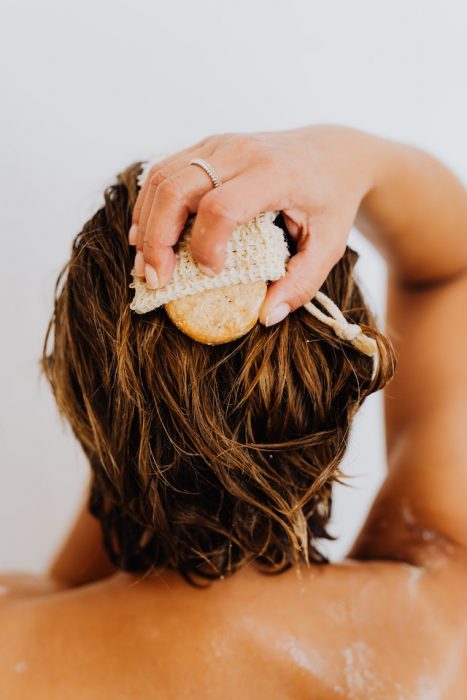 A person scrubbing their scalp and hair. Supplements are great for women who want healthier hair.