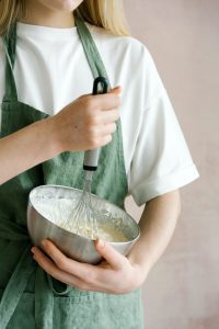 woman is whisking flour and other ingredients to create the best dessert fryer