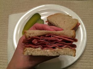 An image of a person's hand holding a sandwich.