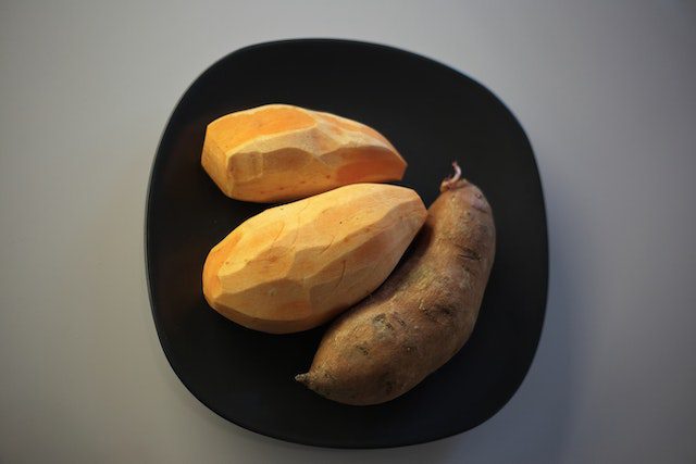 three peeled sweet potatoes ready for baking in air fryer