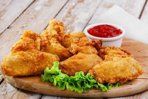 Air fryer chicken wings meal beautifully presented with yummy dipping sauce on a wooden table. These chicken wings are prepared the healthy way.