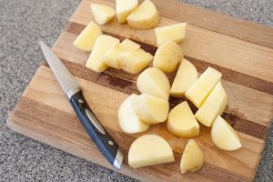 Cutting potatos in a cutting board