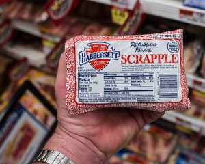 Man holding a scrapple in the grocery