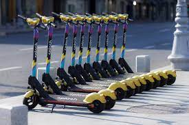 A row of yellow scooters parked on the street