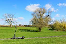 A scooter placed in a rural area.