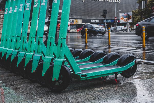 Scooters are neatly parked along the sidewalk, their compact frames aligned in an orderly row. Colorful and diverse, they await their riders, offering a sense of urban mobility and potential adventures.