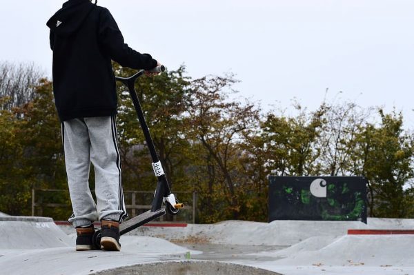 The man is about to ride his scooter on the icy road