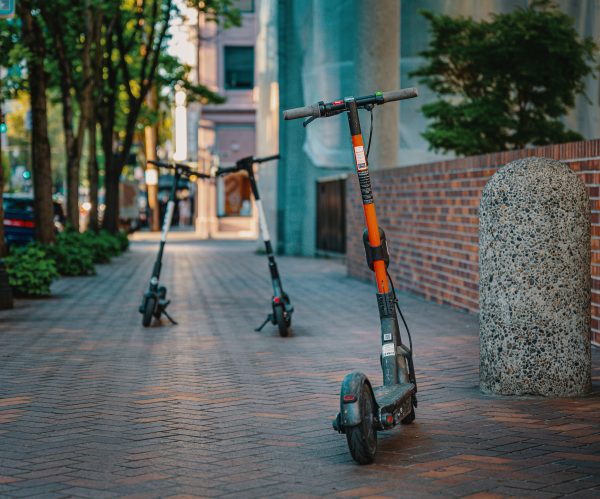  An electric scooter and manual scooters are parked.