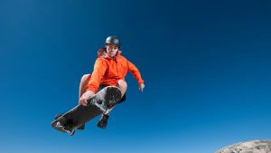 With effortless style, a man is performing a remarkable trick of skating, sporting shorts and a jacket.