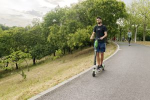 A man using his scooter on ascending drives outside.