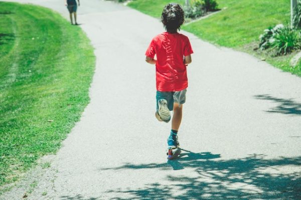 A kid riding a scooter.