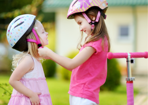 Sisterly love shines as one adjusts another's helmet, securing protection. Shared scooter ride awaits, giggles harmonizing with helmet clicks. Older sibling's careful guidance, a reassuring touch. Helmet snug, safety and trust intertwined. Ready to roll, scooter's promise beckons. Sidewalk adventures and stories yet forged. Two hearts race, one scooter, endless laughter. A bond bolstered by helmet's embrace. As wheels turn, sisterly bond strengthens. One scooter, two spirits, unbreakable connection. Through alleys and dreams, they journey together. Helmeted and joyful, a snapshot of love.