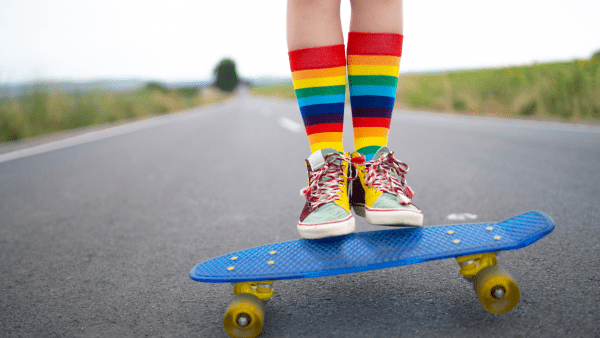 A penny skateboard on the road & 2 feet