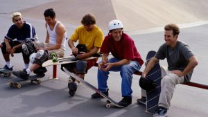 Some men holding their skates and chatting happily.