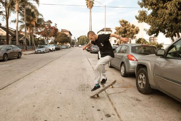 Skating or skateboarding: A man is safely skateboarding.