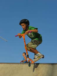 A boy making the most out of life while riding his scooter