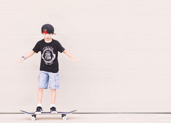 A boy practicing to skate on a skateboard safely.