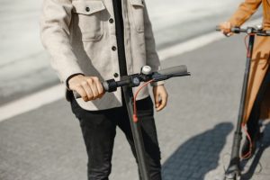 A man gripping the handlebars of a micro-mobility vehicle