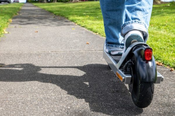 Riding scooter down the street. Scooters can be used both inside and outside environments.