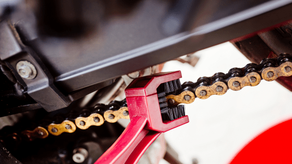 Cleaning scooter chain with a brush