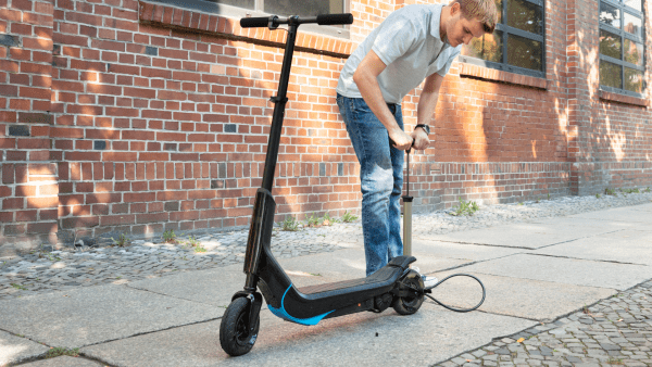 A man pumping air to his scooter.