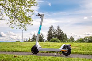 White scooter design parked in green field.