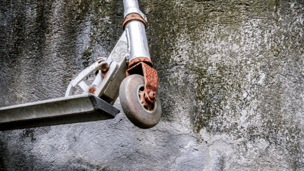 A plain scooter covered with rust. 