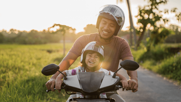 Father and daughter riding a scooter. 