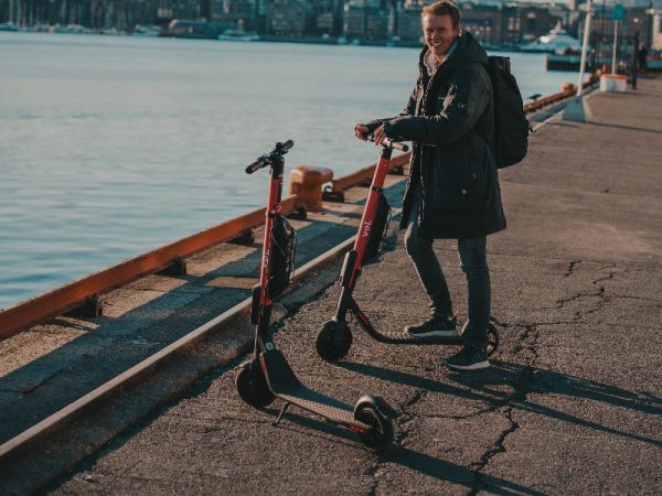 man by the beach while using his e-scooter