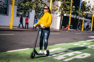 this woman is traveling to school: take note road safety when scooting is of utmost importance ensure a safe and enjoyable experience. Always wear a helmet and other appropriate safety gear, obey traffic rules, use designated bike lanes or pathways whenever possible, and stay vigilant of your surroundings avoid potential hazards.